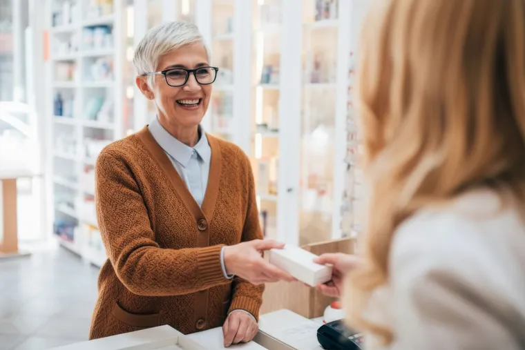 Apothekerin berät eine Kundin am Tisch